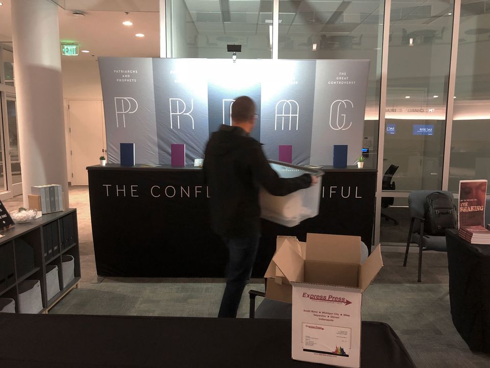 Mark setting up the booth at the 2018 Society of Adventist Communicators Convention.